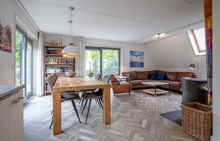 Ruime woonkamer van Vakantiehuis in De Cocksdorp, Texel met comfortabele zithoek en eethoek, ideaal voor ontspanning op de Waddeneilanden.