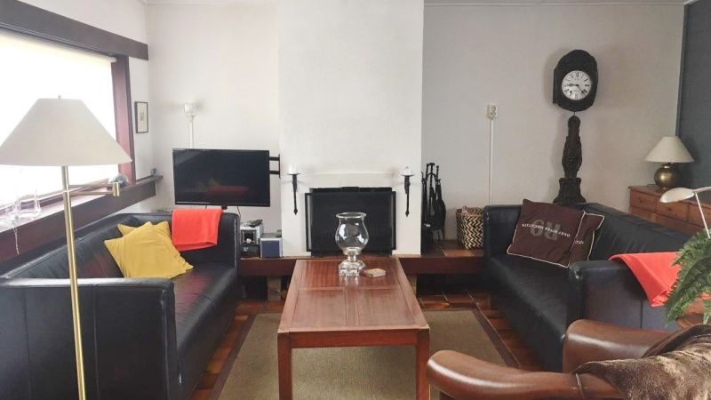 Gezellige woonkamer van Bungalow Slufterduin - De Blauwe Skor in De Cocksdorp, Texel, met comfortabele zithoek en open haard.