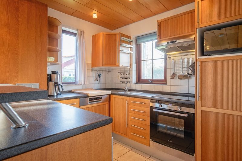 Comfortabele slaapkamer in Villapark Residentie Texel nr. 463, vakantiehuis in De Cocksdorp, Texel, met houten bed en warme sfeer.