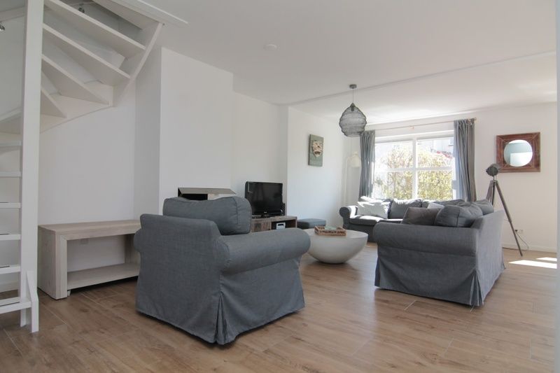 Gezellige woonkamer van Vakantiehuis D 703 in De Cocksdorp, Texel, met comfortabele zitruimte en veel natuurlijk licht.