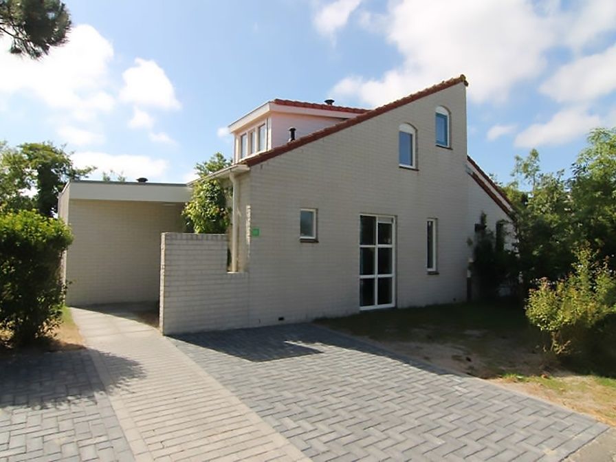 Vakantiehuis D 617 in De Cocksdorp, Texel, biedt een charmante buitenkant met tuinpad en groene omgeving op de Waddeneilanden.