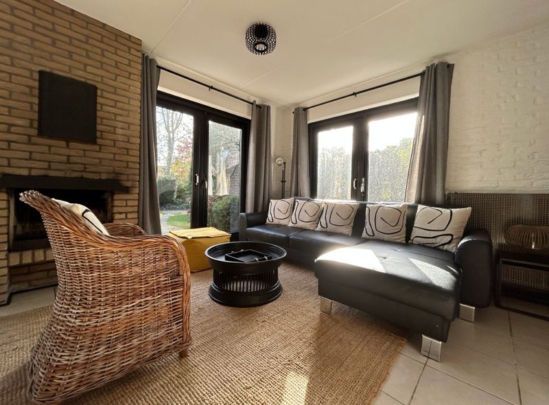 Gezellige woonkamer in Vakantiehuis C 059, De Cocksdorp, Texel met comfortabele zithoek en uitzicht op de tuin.