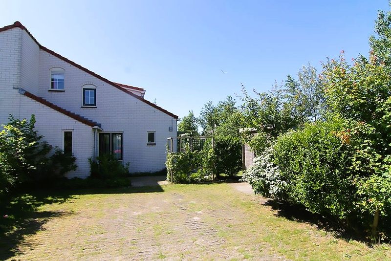 Vakantiehuis D 685 in De Cocksdorp, Texel biedt een serene buitenruimte met weelderige tuin en zonnig terras, ideaal voor ontspanning.