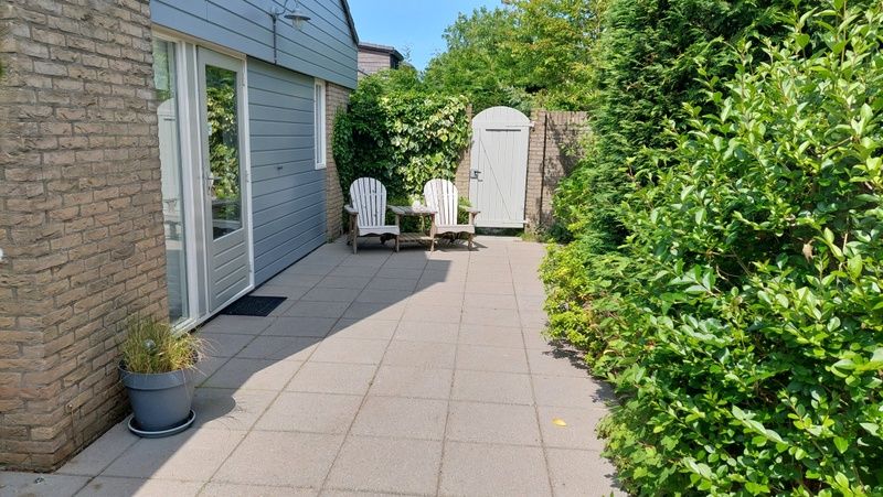 Ontspannen terras bij Vakantiehuis B 223 in De Cocksdorp, Texel. Geniet van de rust en groene omgeving op het Waddeneiland.