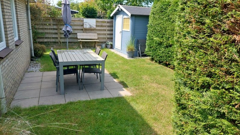 Gezellige tuin van Vakantiehuis B 223 in De Cocksdorp, Texel, met terras en groene omgeving voor een ontspannen verblijf op de Waddeneilanden.