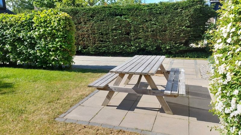 Geniet van de buitenruimte bij Vakantiehuis B 223 in De Cocksdorp, Texel, met een uitnodigend terras en picknicktafel voor ontspanning.