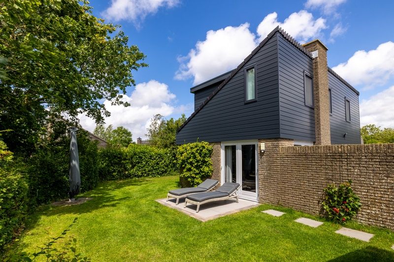 Vakantiehuis A 109 in De Cocksdorp, Texel biedt een serene tuin met ligstoelen, perfect voor ontspanning op de Waddeneilanden.