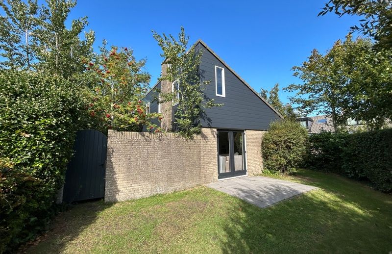 Vakantiehuis A 343 in De Cocksdorp, Texel, biedt een serene buitenruimte met terras, omgeven door groene natuur op de Waddeneilanden.