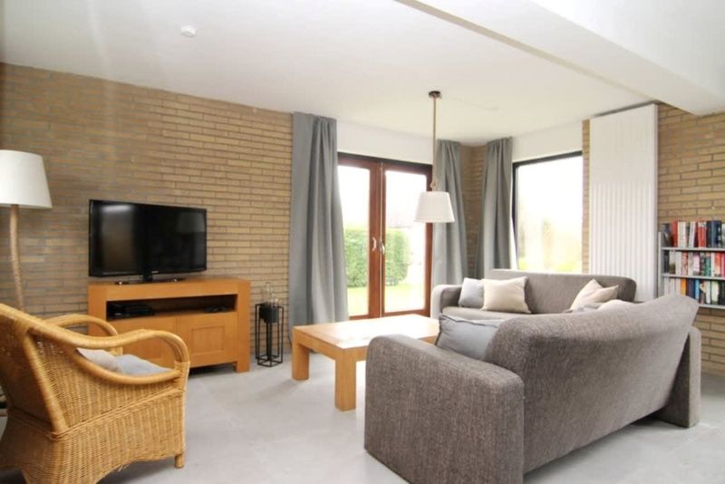 Gezellige woonkamer van Vakantiehuis A 245 in De Cocksdorp, Texel, met comfortabele zithoek en uitzicht op de tuin.