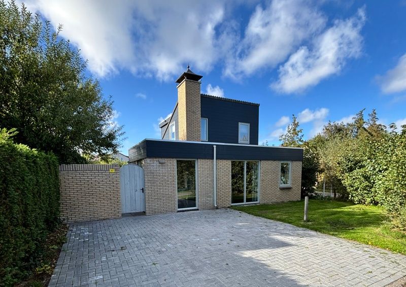 Das Ferienhaus A 381 in De Cocksdorp, Texel, bietet ein modernes Aeusseres mit einer geraeumigen Auffahrt und einer gruenen Umgebung auf den Watteninseln.