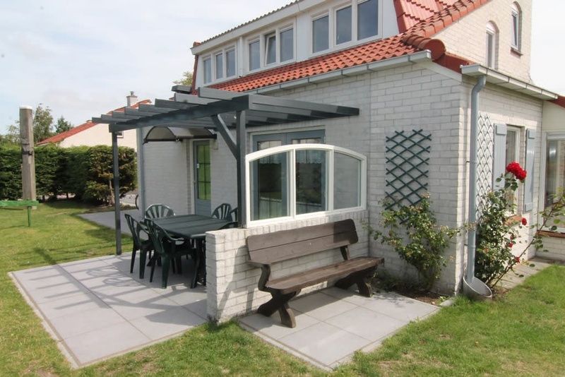 Vakantiehuis D 493 in De Cocksdorp, Texel met uitnodigend terras en groene tuin, ideaal voor een ontspannen verblijf op de Waddeneilanden.