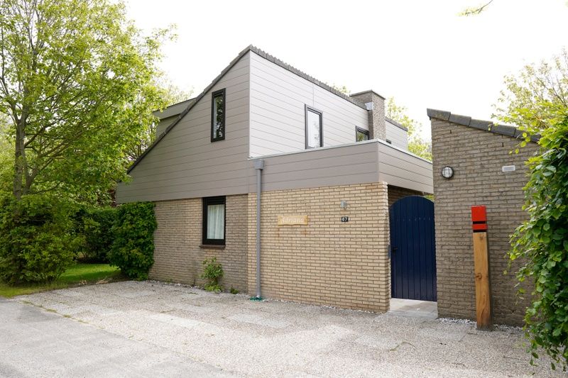 Vakantiehuis C 067 in De Cocksdorp, Texel biedt een uitnodigende voorgevel met moderne architectuur en omringende natuur.