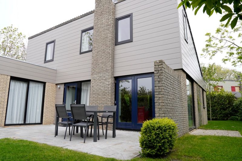 Vakantiehuis C 067 in De Cocksdorp, Texel biedt een uitnodigend terras met moderne zitplaatsen, ideaal voor ontspanning in de natuur.