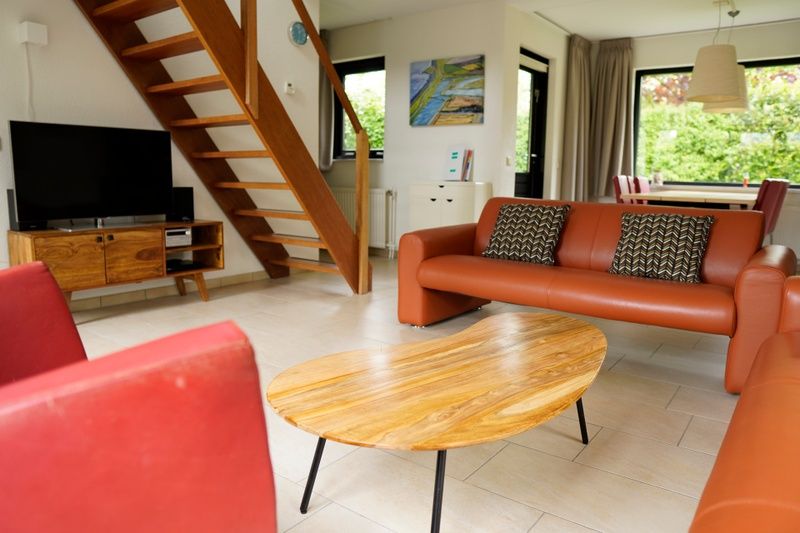 Gezellige woonkamer van Vakantiehuis C 067 in De Cocksdorp, Texel met comfortabele banken en een stijlvolle houten tafel.