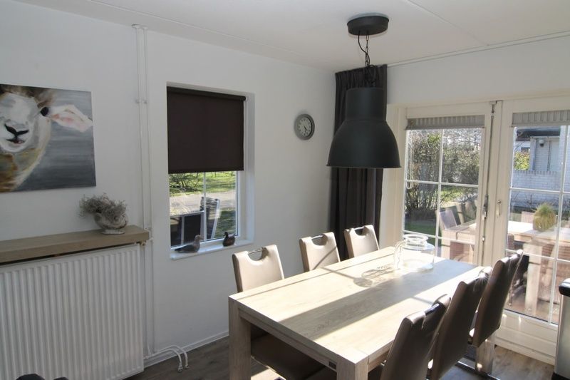 Cozy dining room in Holiday home D 692 in De Cocksdorp, Texel, overlooking the garden and a spacious dining table for family dinners.