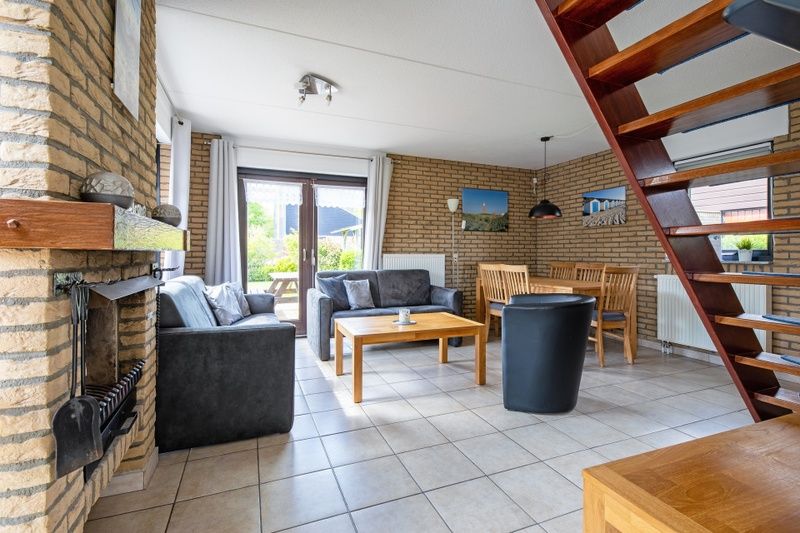 Cozy living room of Holiday home A 309 in De Cocksdorp, Texel, with comfortable seating area and garden view.