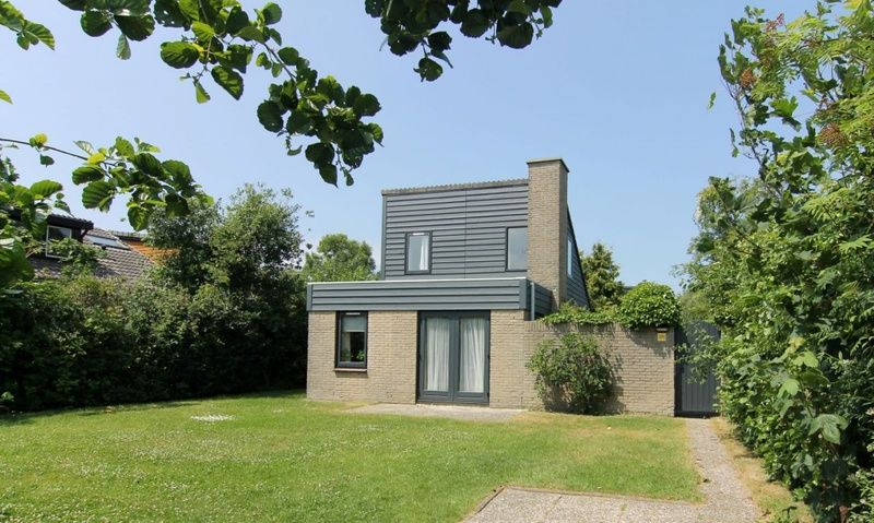 Vakantiehuis B 271 in De Cocksdorp, Texel biedt een serene tuin en moderne architectuur voor een ontspannen verblijf op de Waddeneilanden.