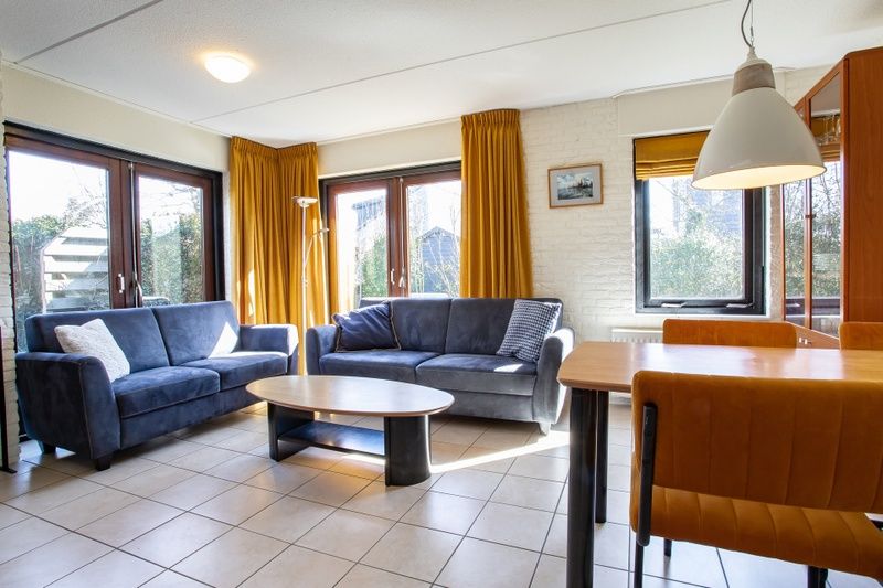 Gezellige woonkamer van Vakantiehuis B 195 in De Cocksdorp, Texel met comfortabele banken en veel natuurlijk licht.