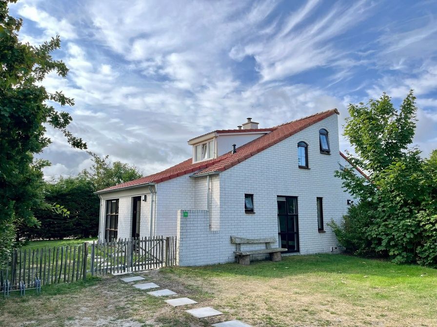 Vakantiehuis D 709 in De Cocksdorp, Texel, biedt een charmant verblijf met rode dakpannen en een groene tuin op de Waddeneilanden.