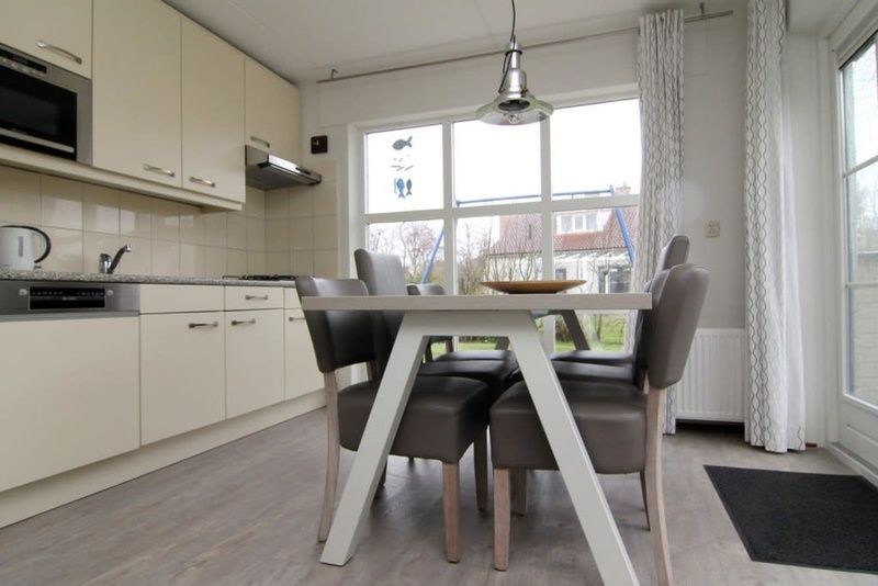 Gezellige eetruimte in Vakantiehuis D 730, De Cocksdorp, Texel. Licht interieur met ruime keuken en uitzicht op de tuin van de Waddeneilanden.