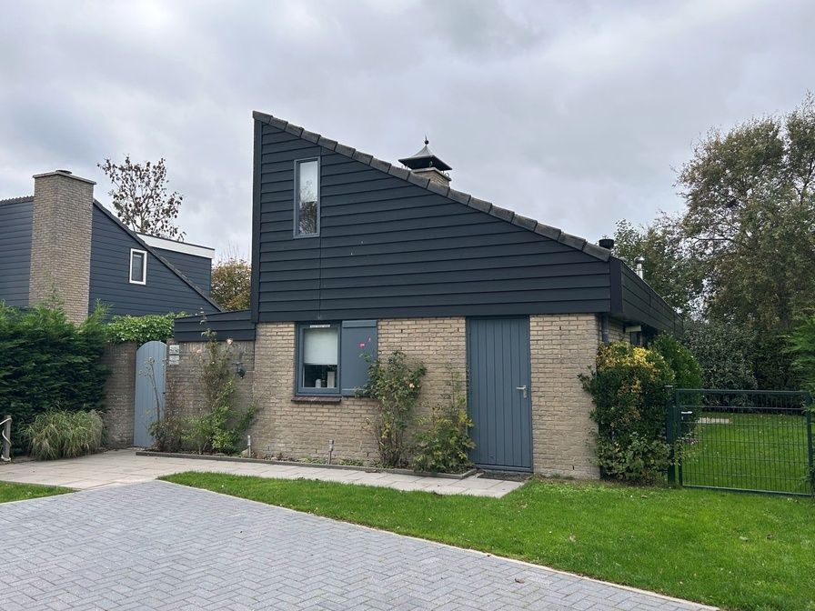 Vakantiehuis A 209 in De Cocksdorp, Texel biedt een charmante buitenkant met moderne architectuur, omgeven door groene natuur op de Waddeneilanden.