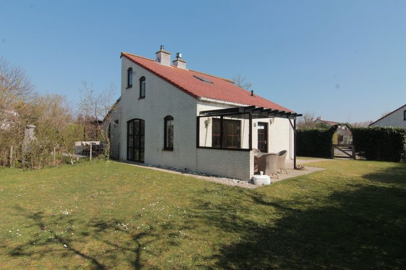 Vakantiehuis D 437 in De Cocksdorp, Texel, biedt een charmant terras met uitzicht op de groene omgeving van de Waddeneilanden.