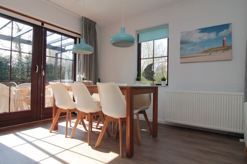 Lichte eetkamer in Vakantiehuis D 437, De Cocksdorp, Texel, met uitzicht op terras en moderne inrichting voor een ontspannen verblijf op de Waddeneilanden.