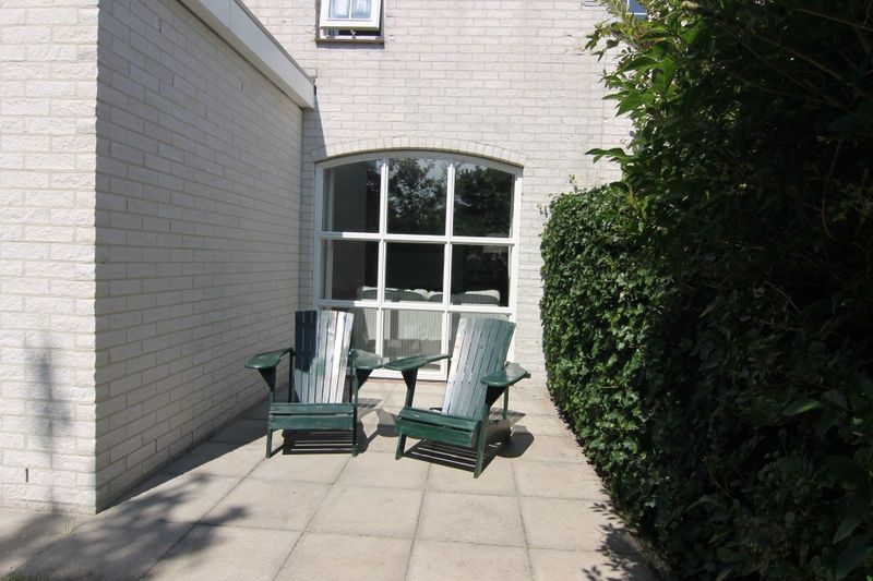 Geniessen Sie die Sonne auf der Terrasse des Ferienhauses D 618 in De Cocksdorp, Texel, umgeben von gruener Natur und Ruhe.