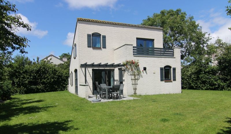Vakantiehuis F 609 in De Cocksdorp, Texel, biedt een ruime tuin en een uitnodigend terras voor een ontspannen verblijf op de Waddeneilanden.