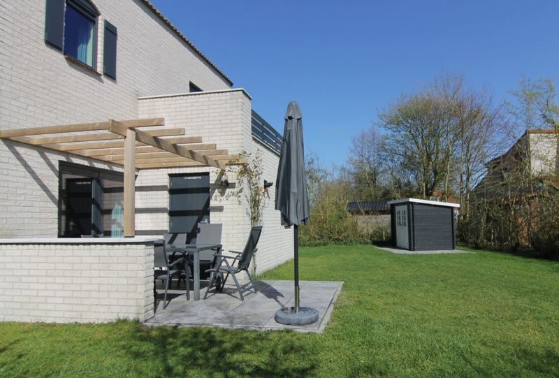 Geniet van de zon op het terras van Vakantiehuis F 609 in De Cocksdorp, Texel, omgeven door groene natuur op de Waddeneilanden.