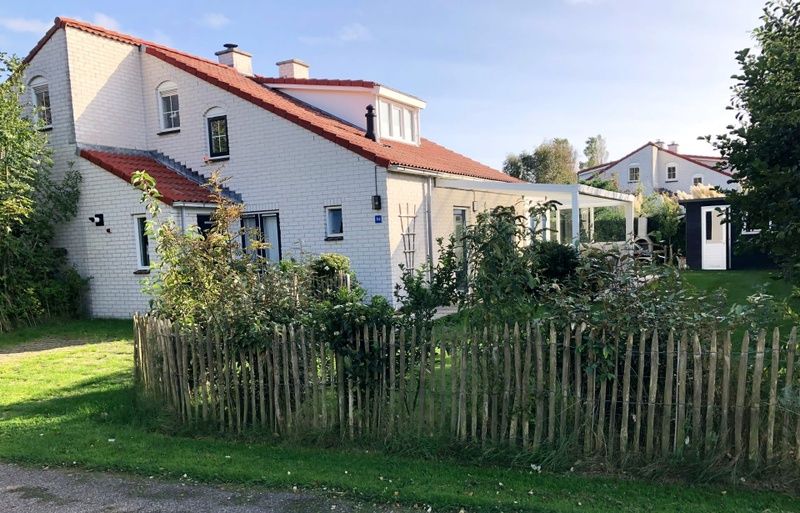 Das Ferienhaus D 748 in De Cocksdorp, Texel, bietet eine charmante Unterkunft mit einer sonnigen Terrasse und einem gruenen Garten, ideal fuer einen erholsamen Urlaub.