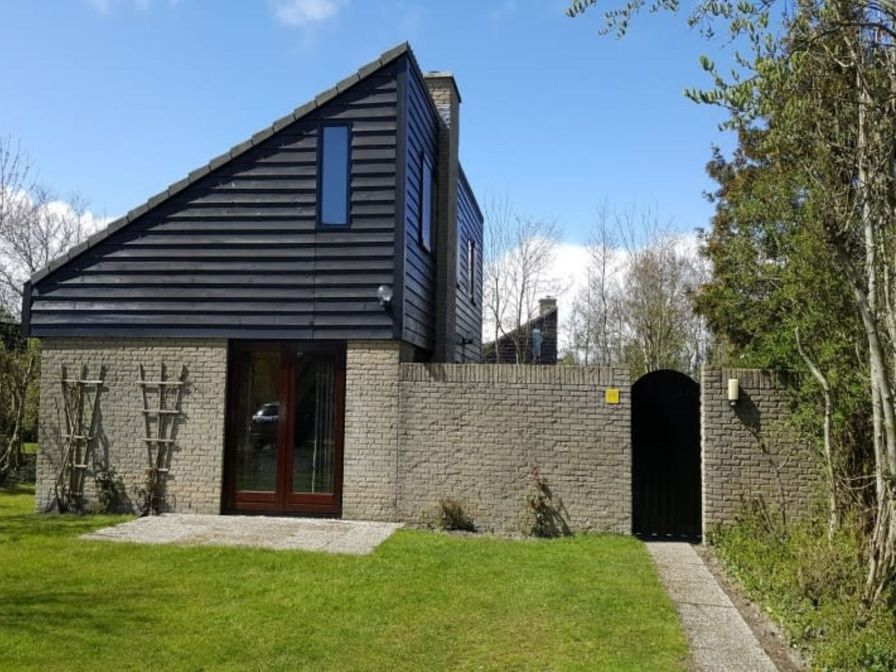 Vacation home A 275 in De Cocksdorp, Texel, offers a serene outdoor space with green garden and modern architecture on the Wadden Islands.