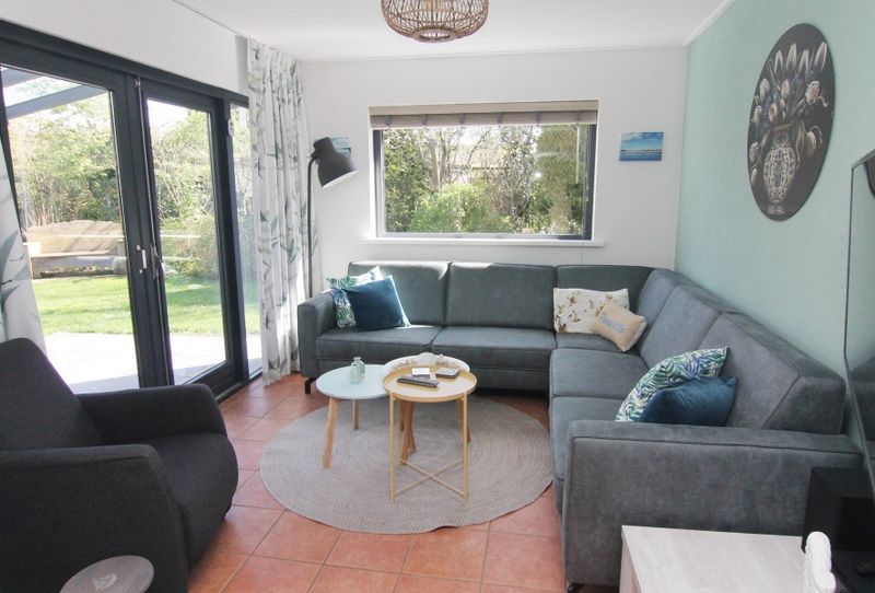 Gezellige woonkamer van Vakantiehuis A 143 in De Cocksdorp, Texel. Comfortabele zitruimte met uitzicht op de groene omgeving.