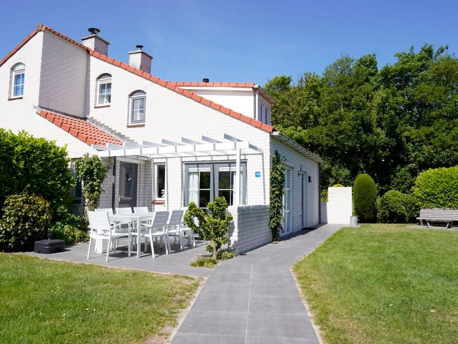 Vakantiehuis D 770 in De Cocksdorp, Texel biedt een charmant terras met tuinmeubilair, omgeven door groene natuur en rust.