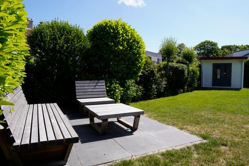 Ontspan op het zonnige terras van Vakantiehuis D 770 in De Cocksdorp, Texel, omgeven door weelderige natuur en rustgevende tuinen.