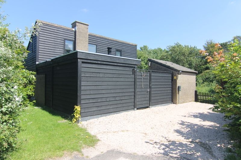 Vakantiehuis C 081 in De Cocksdorp, Texel, biedt een moderne buitenkant met houten gevels en rustige omgeving op de Waddeneilanden.