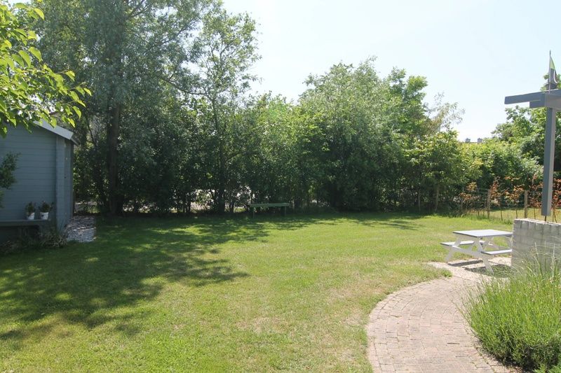 Geniet van de groene tuin bij Vakantiehuis D 610 in De Cocksdorp, Texel, met veel privacy en natuurrijke omgeving op de Waddeneilanden.