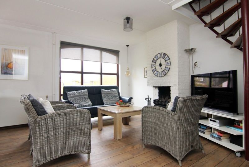 Gemuetliches Wohnzimmer des Ferienhauses D 401 in De Cocksdorp, Texel. Gemuetliche Sitzecke mit Kamin und moderner Einrichtung fuer ultimativen Urlaubsgenuss.
