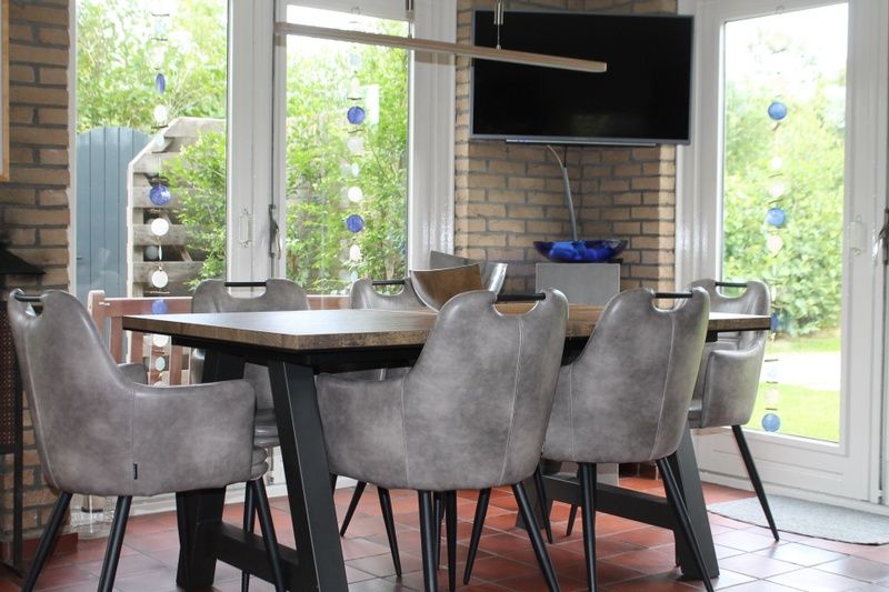 Gezellige eetkamer in Vakantiehuis A 267, De Cocksdorp, Texel. Comfortabele stoelen en veel lichtinval voor een ontspannen verblijf.