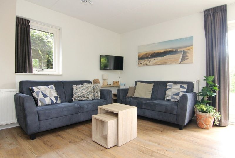 Gezellige woonkamer in Vakantiehuis A 287, De Cocksdorp, Texel, met comfortabele banken en moderne inrichting voor een ontspannen verblijf.