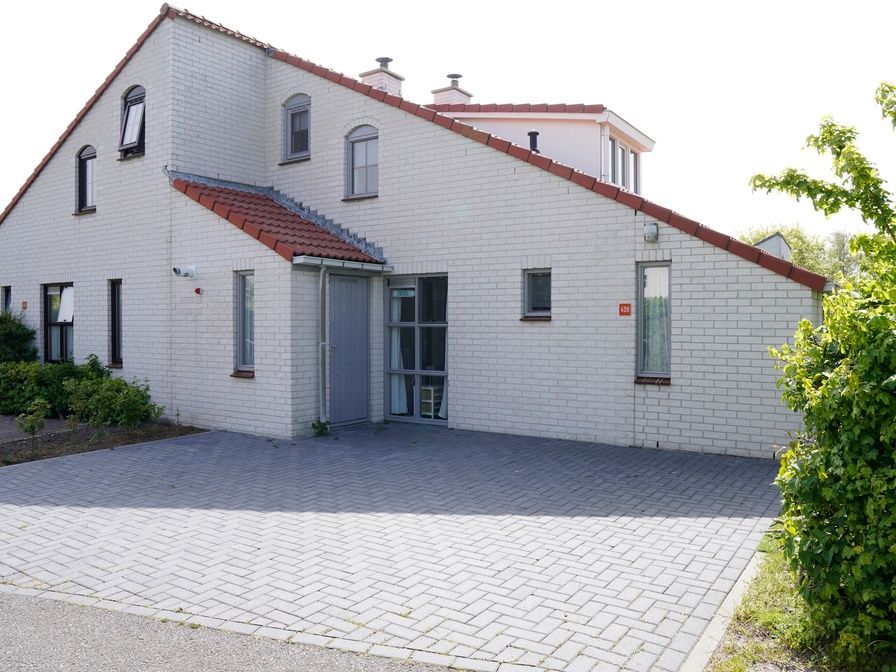 Das Ferienhaus D 439 in De Cocksdorp, Texel, bietet ein charmantes Aeusseres mit einer geraeumigen Auffahrt, ideal fuer einen entspannten Aufenthalt auf den Watteninseln.