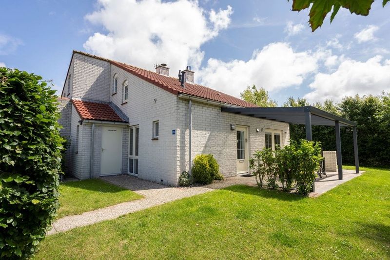 Das Ferienhaus D 756 in De Cocksdorp, Texel, bietet einen schoenen Aussenbereich mit Terrasse und gruenem Garten, ideal fuer einen entspannten Aufenthalt.