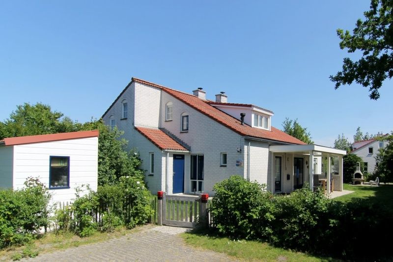 Das Ferienhaus D 707 in De Cocksdorp, Texel, bietet eine charmante Unterkunft mit einer sonnigen Terrasse und gruener Umgebung auf den Watteninseln.