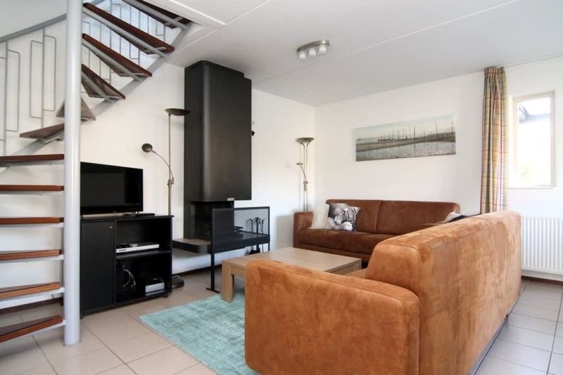 Gemuetliches Wohnzimmer des Ferienhauses D 760 in De Cocksdorp, Texel mit bequemer Sitzecke und moderner Einrichtung.