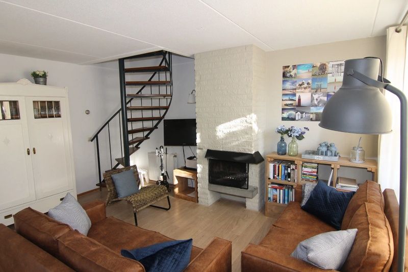 Gezellige woonkamer van Vakantiehuis D 696 in De Cocksdorp, Texel met comfortabele zithoek en sfeervolle open haard.