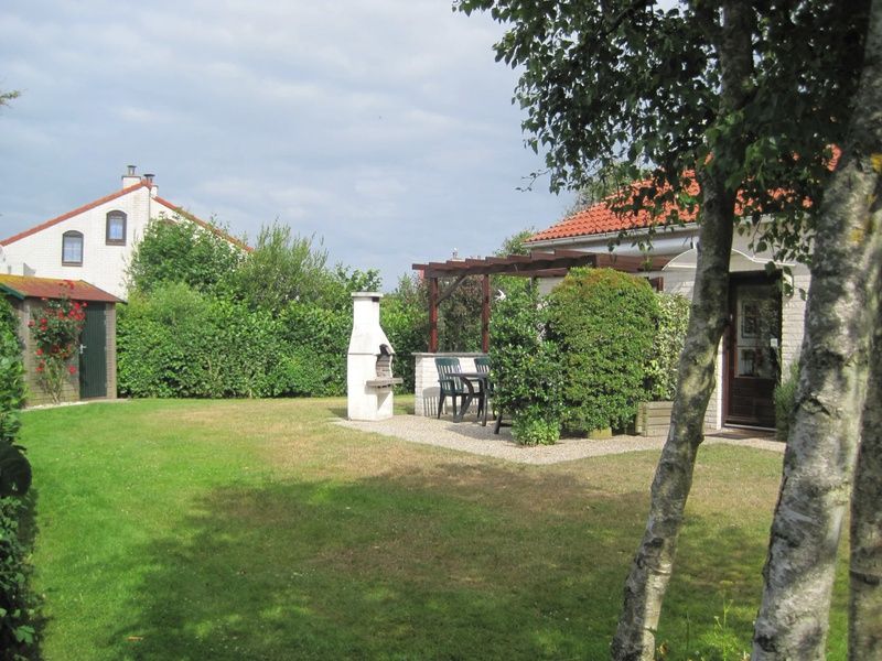 Geniet van de groene tuin en terras van Vakantiehuis D 521 in De Cocksdorp, Texel, ideaal voor een ontspannen verblijf op de Waddeneilanden.
