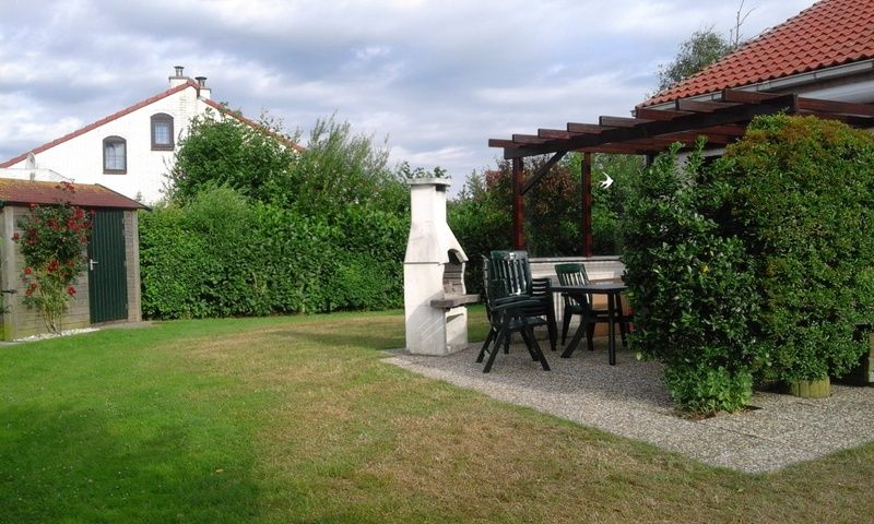 Geniet van de groene tuin en het gezellige terras bij Vakantiehuis D 521 in De Cocksdorp, Texel, ideaal voor een ontspannen verblijf.