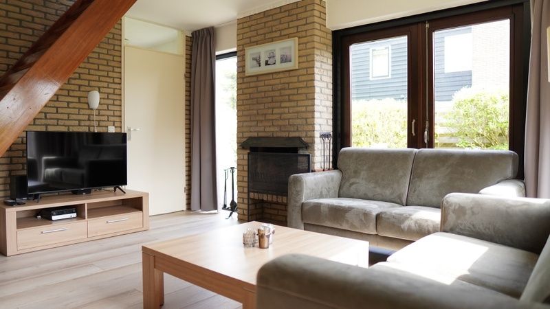 Gezellige woonkamer van Vakantiehuis B 031 in De Cocksdorp, Texel met comfortabele zithoek en grote ramen.