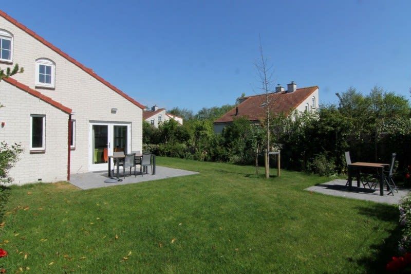 Geniet van de groene tuin en het terras van Vakantiehuis D 706 in De Cocksdorp, Texel, een ideale plek voor ontspanning op de Waddeneilanden.