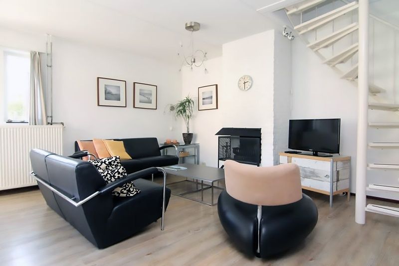 Gezellige woonkamer in Vakantiehuis D 706, De Cocksdorp, Texel met moderne inrichting en comfortabele zithoek.